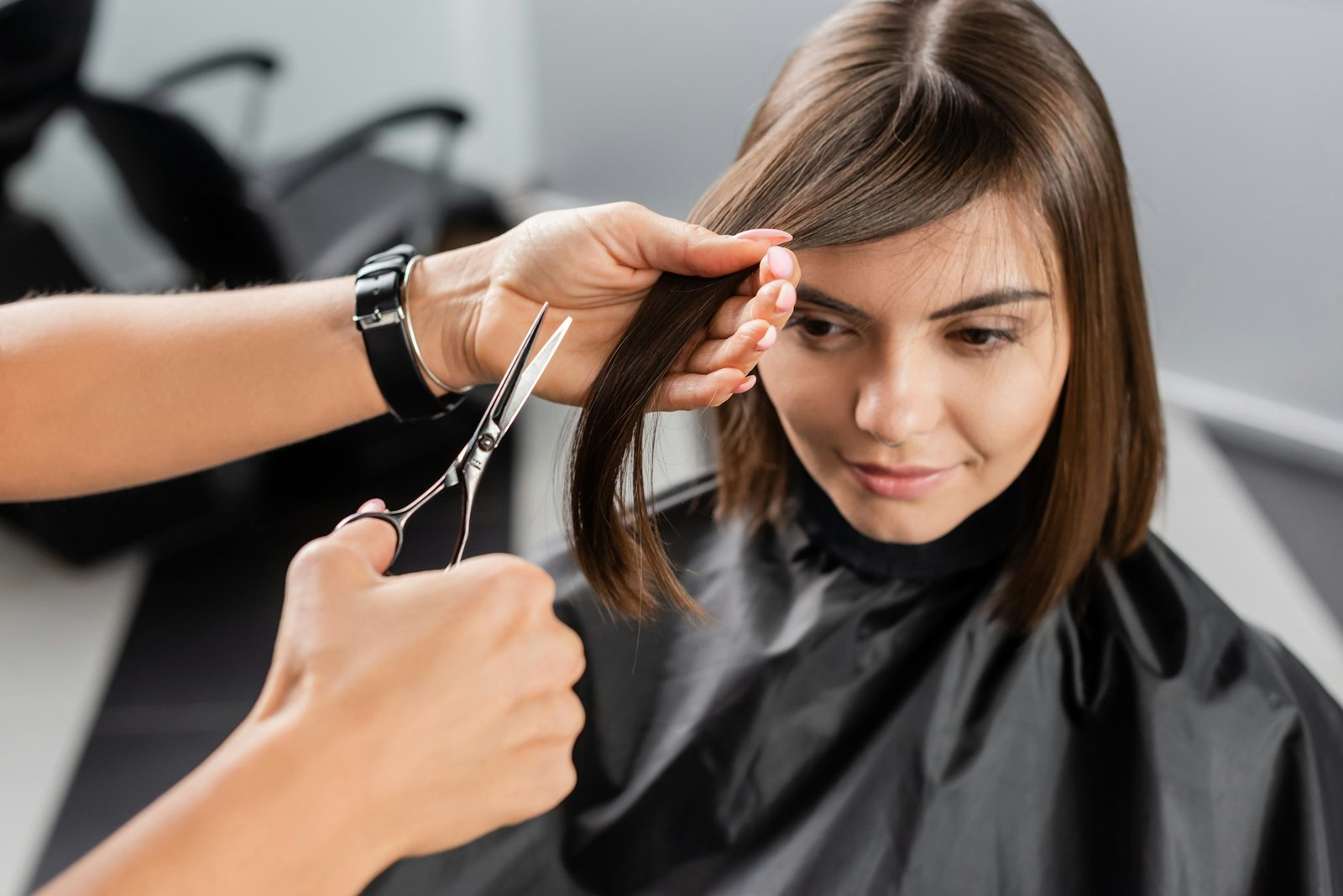 beauty profession, hairdo, hair stylist cutting short brunette hair of young woman, haircut,