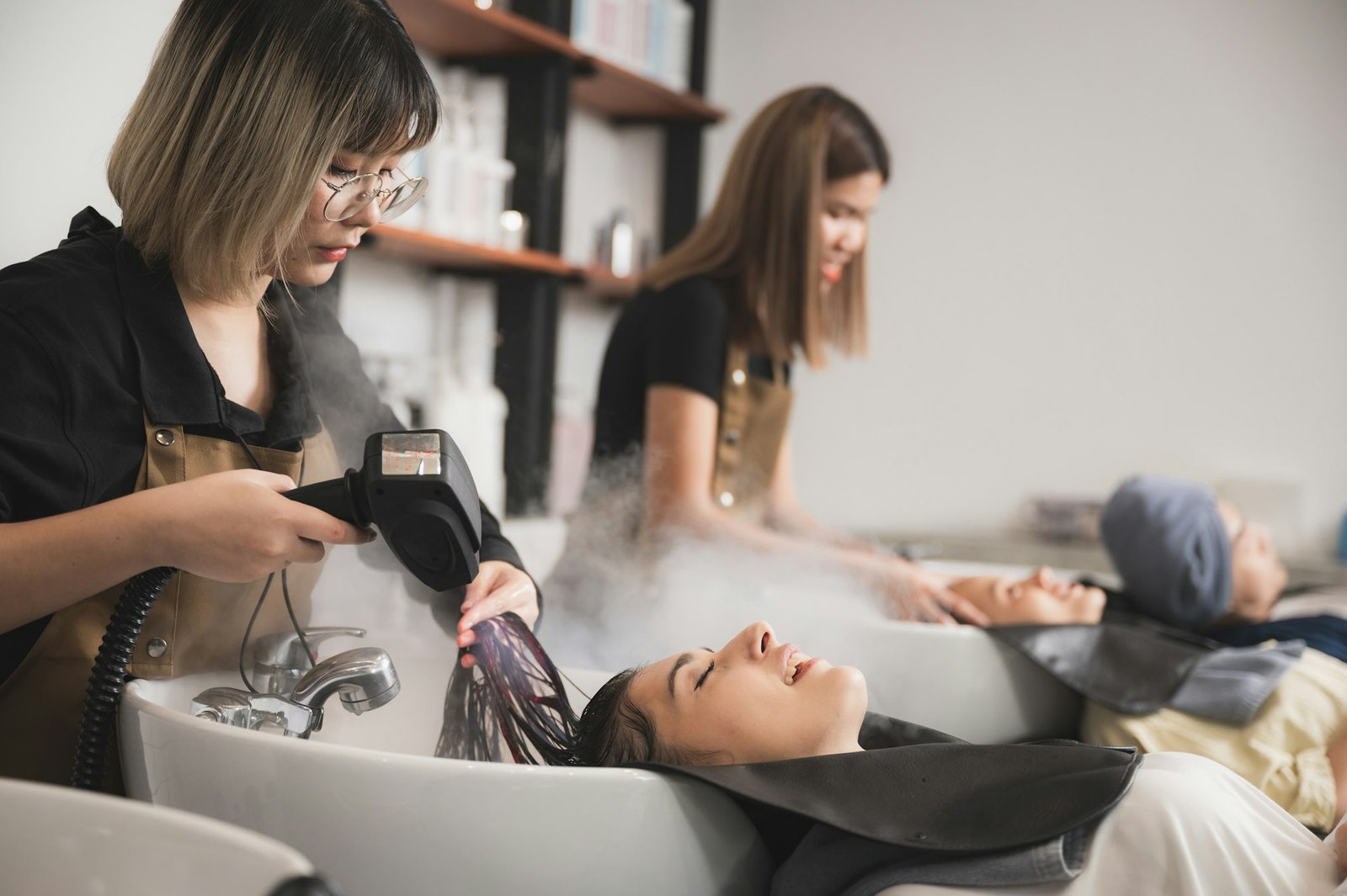 hairdresser doing hair washing and hair spa to the beautiful young women client at salon