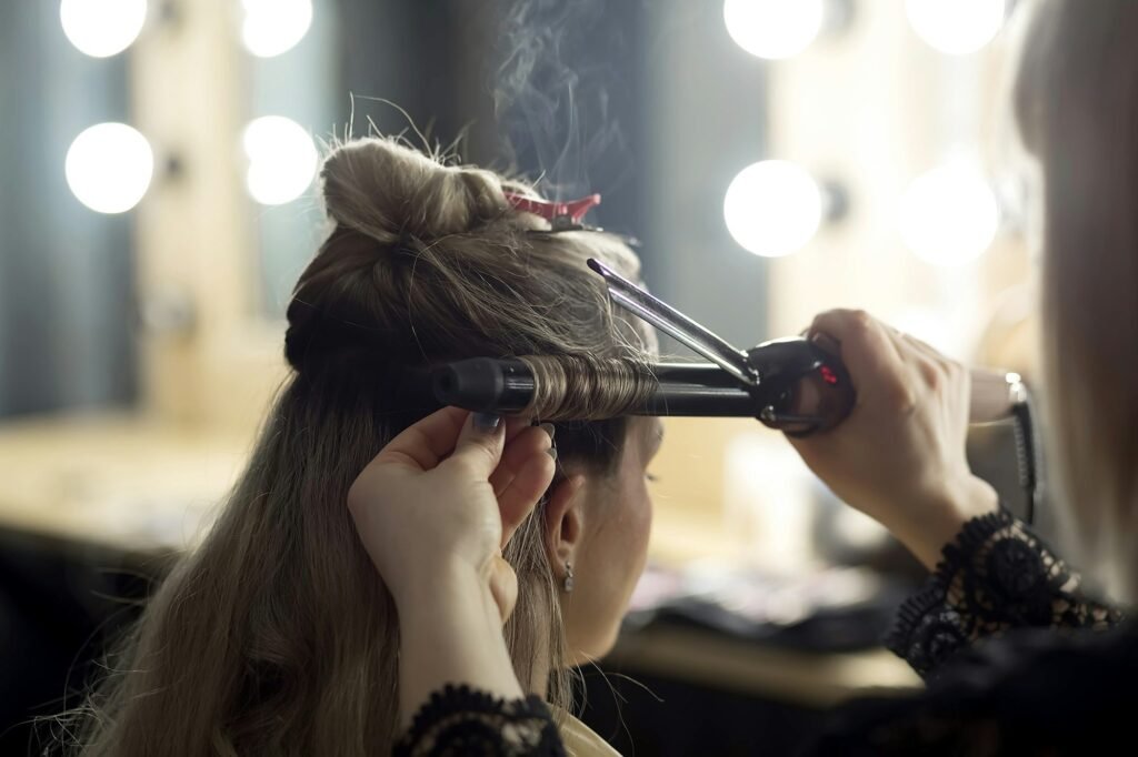 Makeup artist doing hair styling on a curling iron