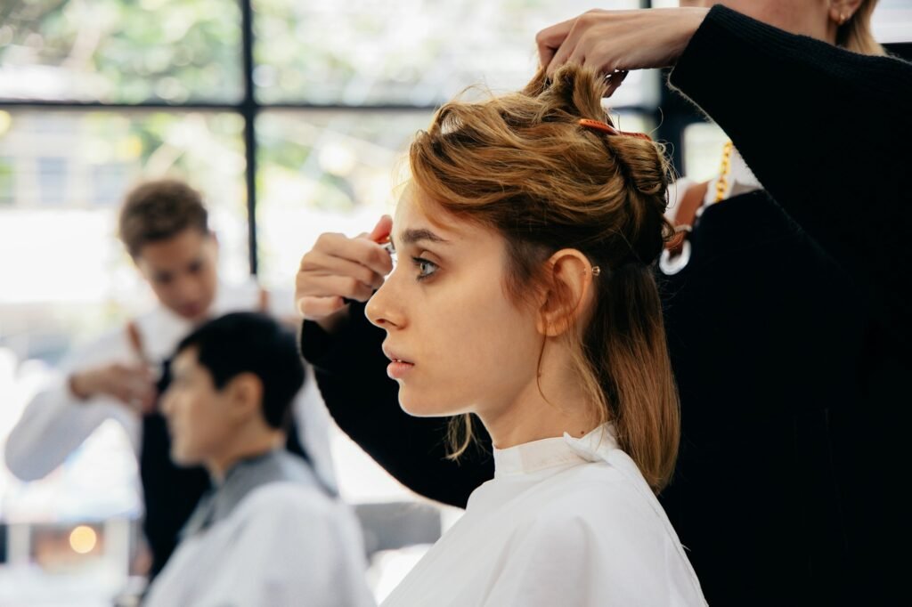 Young woman in parlour getting hairstyling